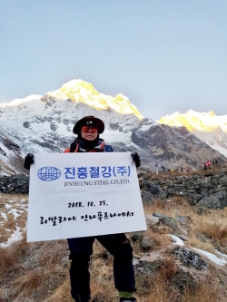 아침 햇살이 만년설에 비추어 황금색으로 보여지는 골든 마운틴 앞에서 기념 촬영 중인 진흥철강(주) 최홍락 대표